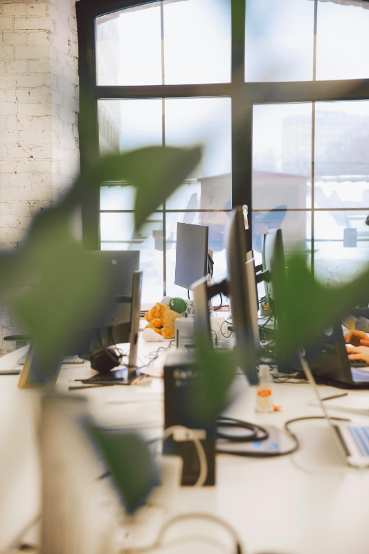 A sleek, minimalist office space with floor-to-ceiling windows, showing insurance professionals working on transparent glass displays with holographic insurance policy visualizations, bathed in natural light